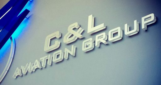 metal faced acrylic in brushed aluminun on frosted clear acrylic mounted for aviation company interior lobby wall