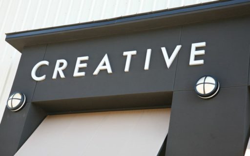 painted white cast aluminum letters mounted outside on stucco building