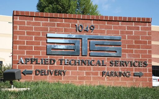 mirror polished solid cut stainless steel letters and logo mounted outside on brick monument
