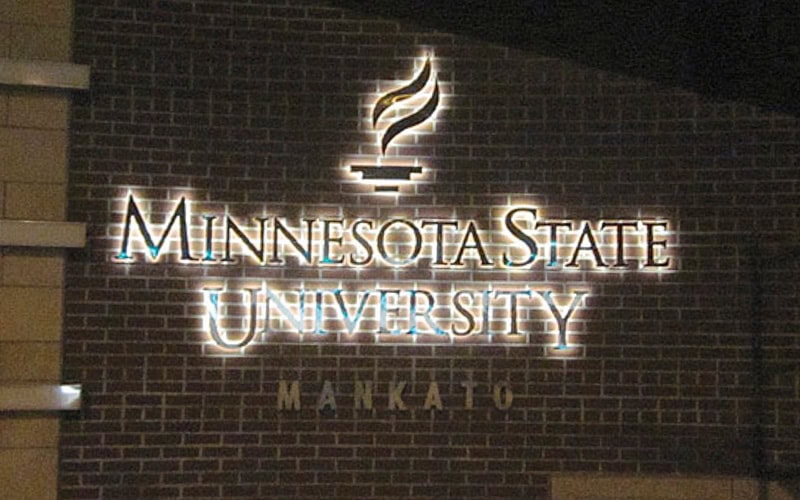 metal backlit sign with white backlight on a brick wall