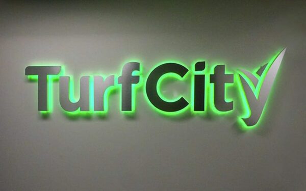 Brushed stainless steel backlit logo sign with green LEDs — Turf