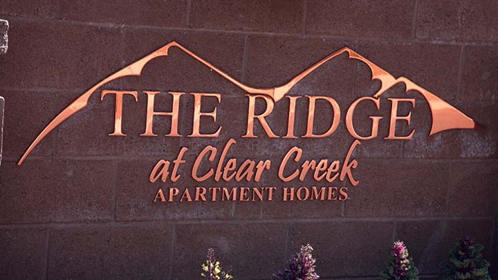 custom exterior copper sign with mountain design on brick wall