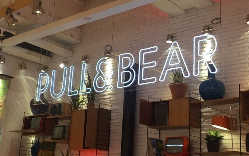 interior LED sign with white LEDS hanging in front of white brick wall