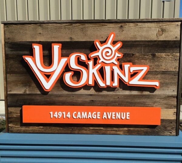 Layered orange and white acrylic logo sign for UV Skinz