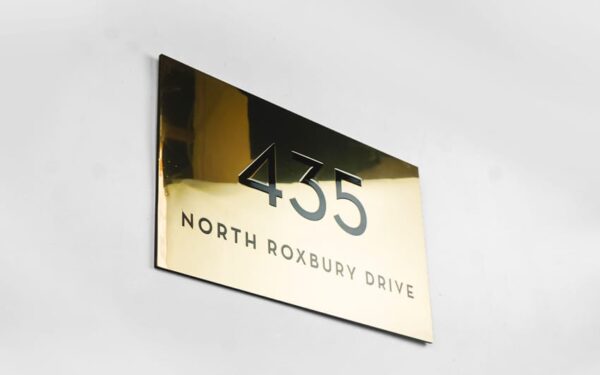 Polished brass storefront address plaque — North Roxbury