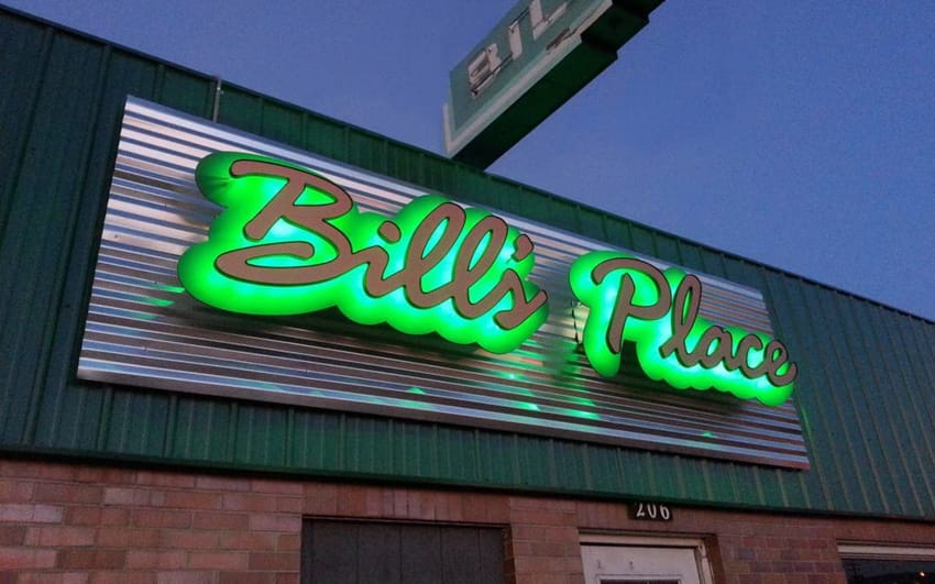 Backlit letters with green leds mounted on corrugated metal on building exterior