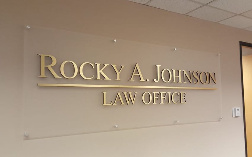 Frosted acrylic panel sign with a metal-laminate face for a law office interior wall