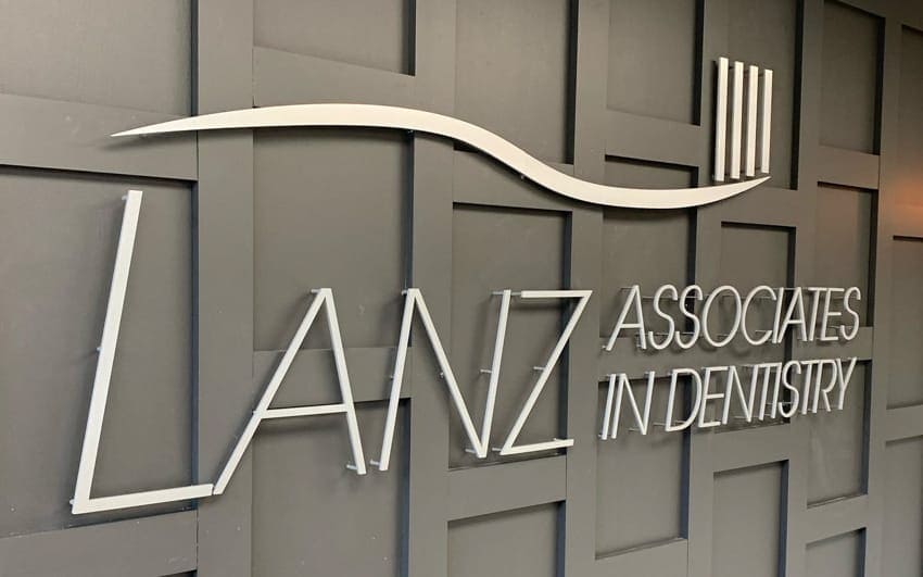 Brushed aluminum dimensional lobby letters on a dentistry reception wall — Lanz Associates in Dentistry