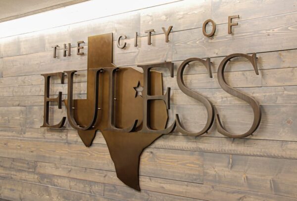 Oxidized Bronze logo mounted on wood plank lobby wall - Euless Texas