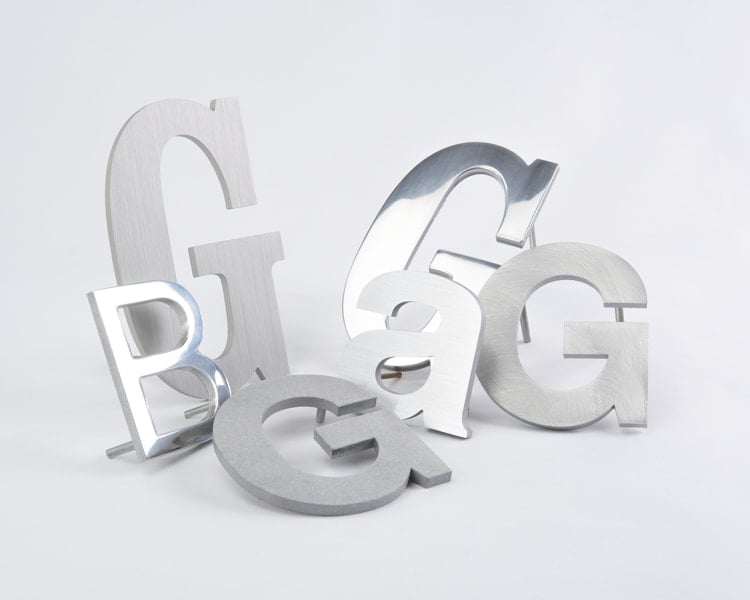 Grouping of brushed and polished solid aluminum sign letters