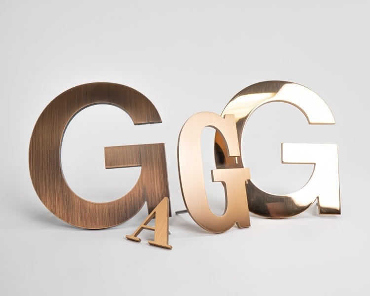 Grouping of solid bronze sign letters in multiple finishes