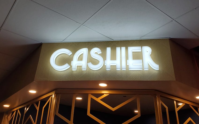 Acrylic front-lit letters with internal LEDs above an interior checkout counter