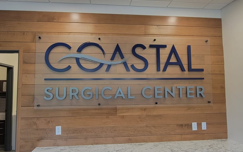 Acrylic logo on a frosted acrylic panel sign — Coastal office lobby