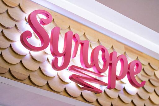 Matte pink painted backlit metal letters with natural white LEDs — Syrope storefront
