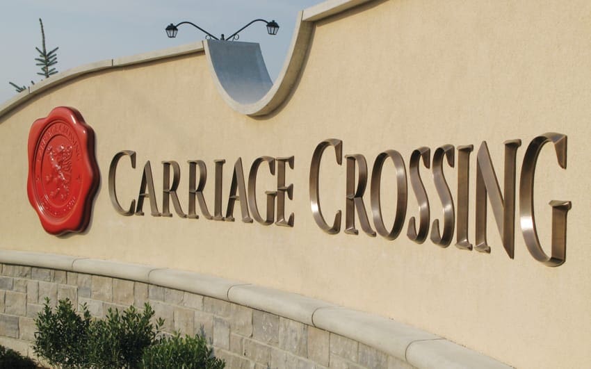Cast bronze sign with an oxidized prismatic-edge finish at a building entrance