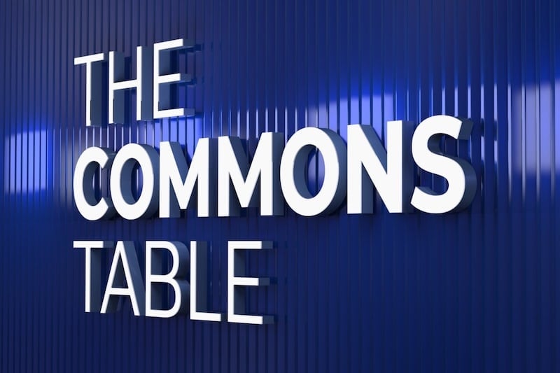 Trimless front-lit channel letters for The Commons Table, lit on blue wall
