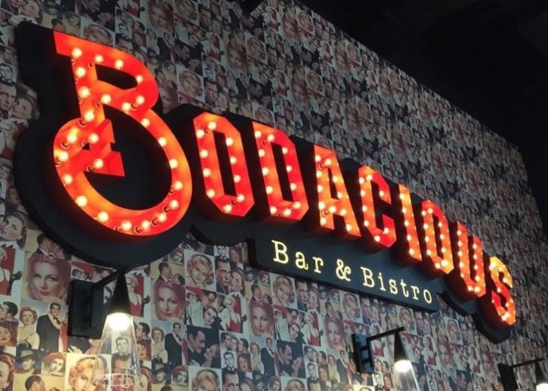 Exposed-bulb marquee lighted letters on a restaurant exterior — Bodacious Bar & Bistro